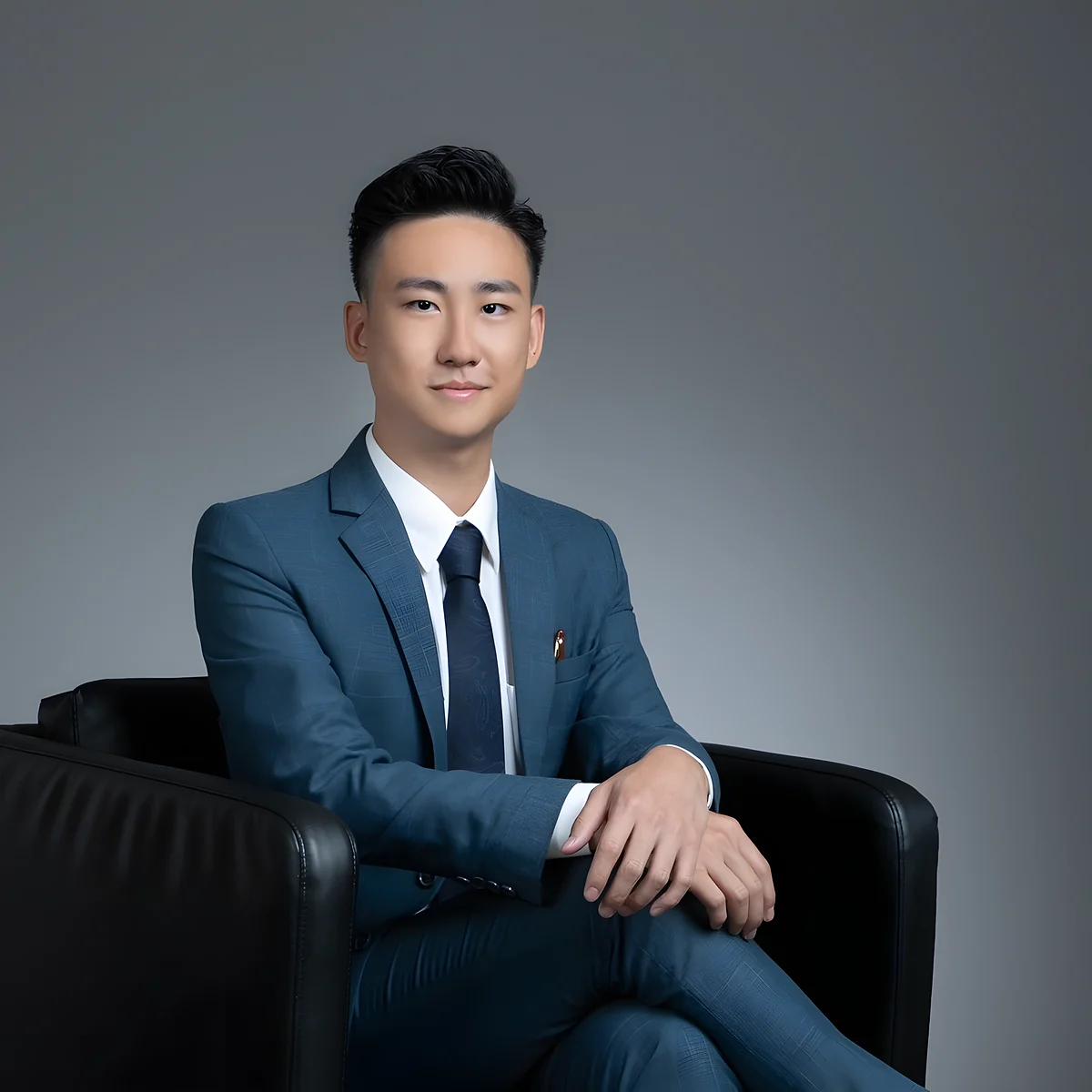 Kimchi Kam,AIA友邦保險理財顧問,穿藍色西裝坐喺黑色皮椅上